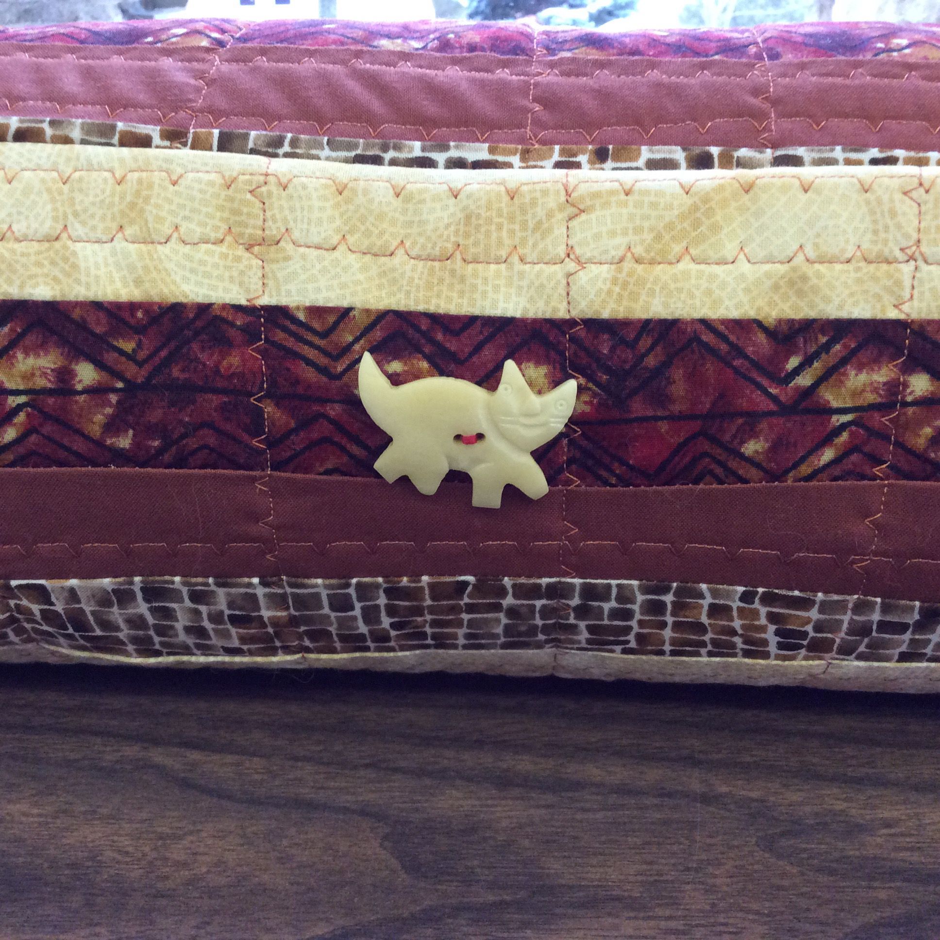 Decoratively stitched solid and print fabrics with ivory cat button embelishment